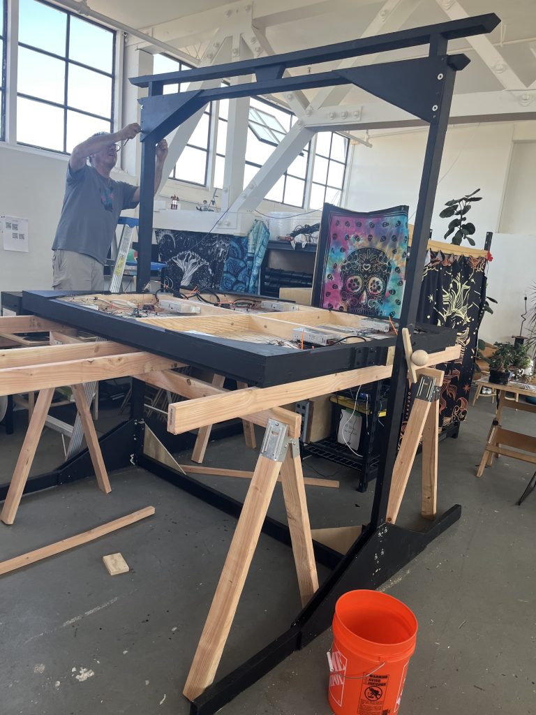 Artist "Bill" working on the PF3000 frame in a warehouse.  The display is rotated horizontally within the frame.